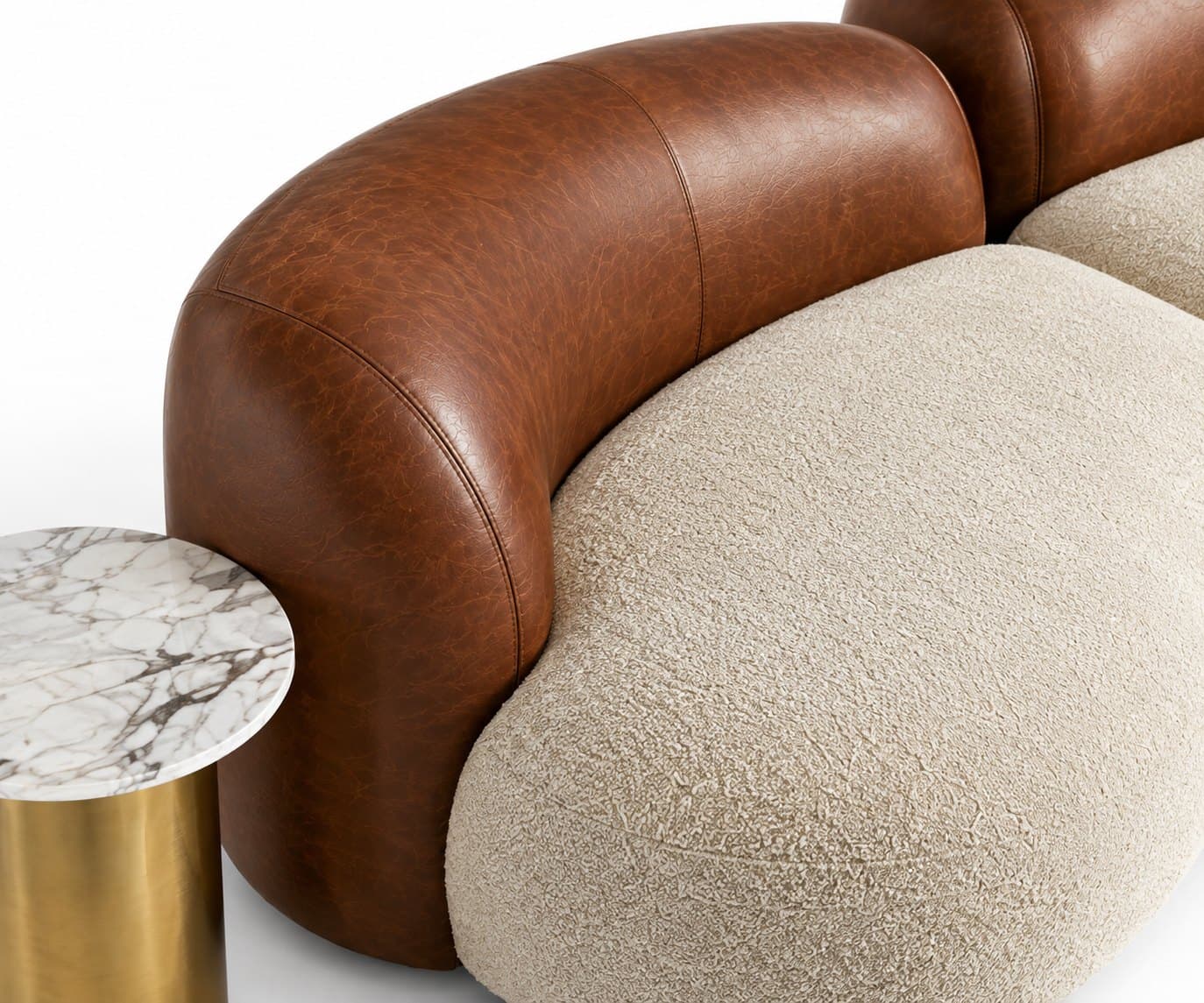 Close-up of the sofa where the tan leather back meets the cream bouclé seat